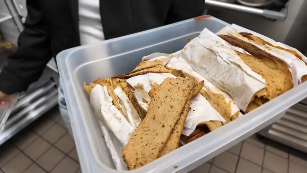 Maciel holding a container of sliced seitan made at Maciel’s Plant-Based Butcher Shop, where some of the best vegan sandwiches in LA are made using products made in-house