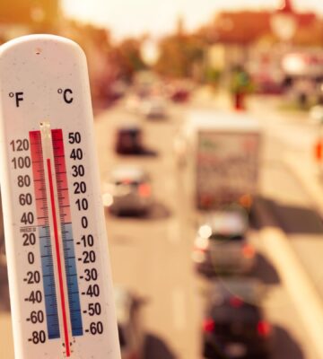 Photo shows a thermometer in someone's hand on an overpass above a busy road. Temperatures in the UK could hit 40C this week for the second time since records began, and animal agriculture is responsible