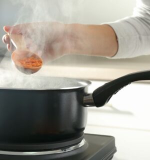 Photo shows a woman's hand as she cooks red lentils in a saucepan. The Netherlands has reduced its national meat recommendations for omnivores by at least 40 percent