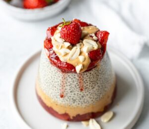 Peanut Butter Jelly Chia Pudding with almond milk, strawberry jam, and chopped peanuts