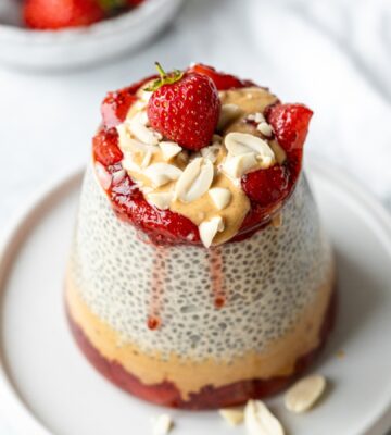 Peanut Butter Jelly Chia Pudding with almond milk, strawberry jam, and chopped peanuts