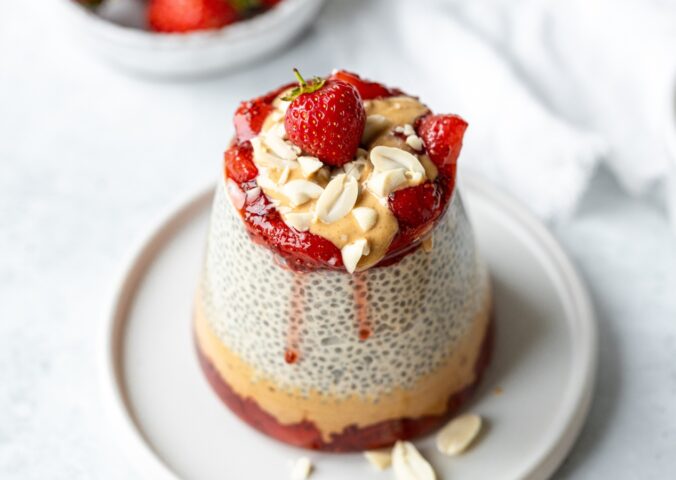 Peanut Butter Jelly Chia Pudding with almond milk, strawberry jam, and chopped peanuts