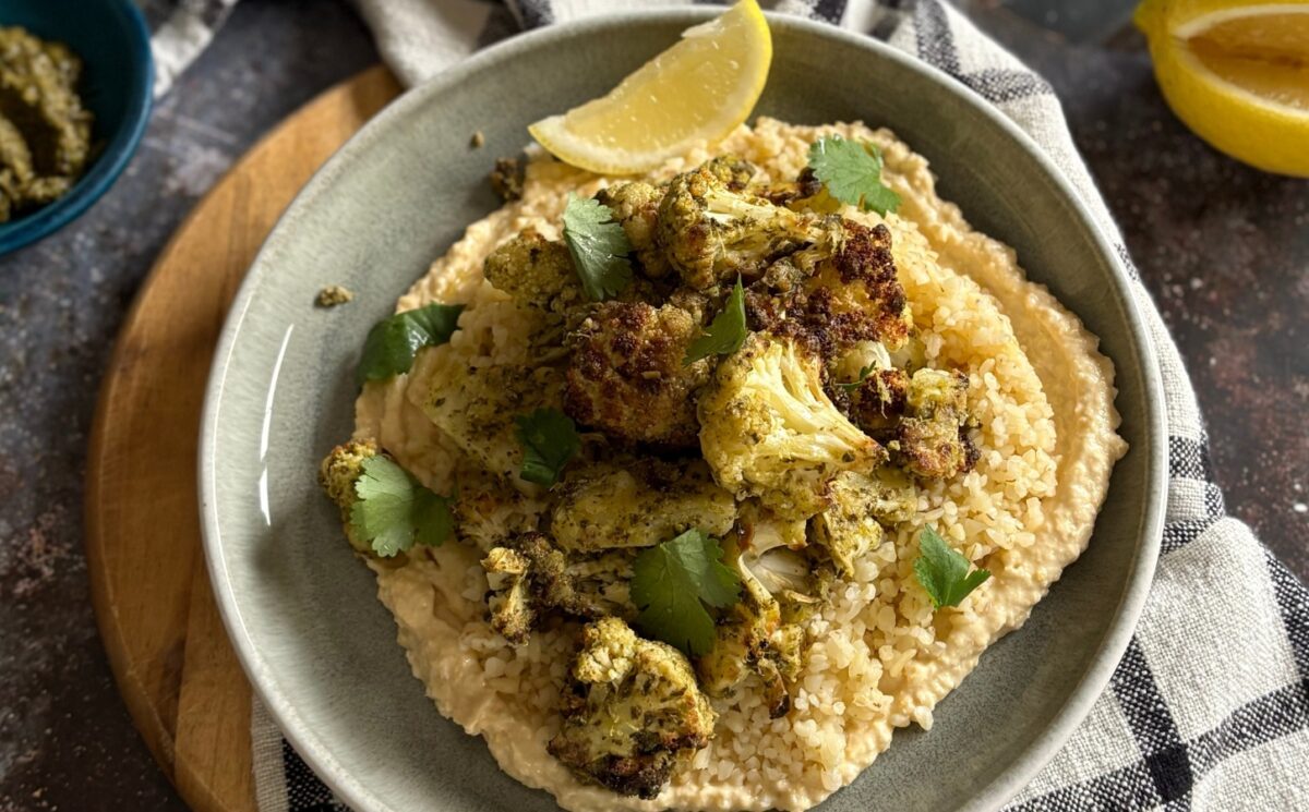 pesto cauliflower bites over grains and hummus served with lemon for vegan summer side dishes