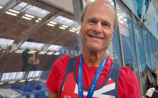 Photo shows Dr Doug Graham, a raw vegan fitness coach and champion powerlifter, wearing a medal from a recent event.