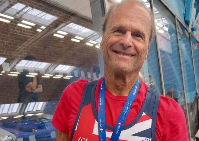 Photo shows Dr Doug Graham, a raw vegan fitness coach and champion powerlifter, wearing a medal from a recent event.