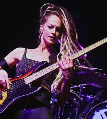 Photo shows vegan rock star Tanya O'Callaghan, who was recently interviewed by Plant Based News, playing bass onstage