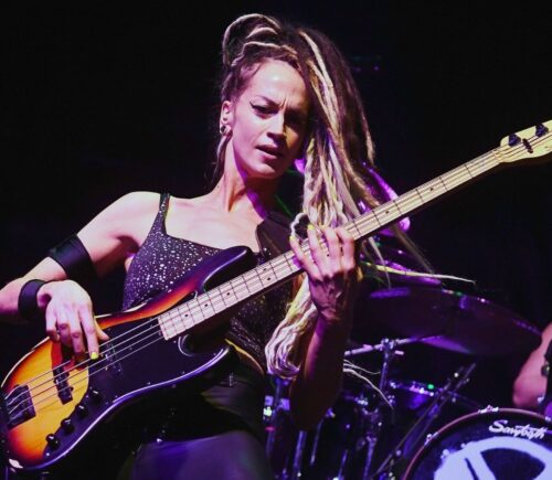 Photo shows vegan rock star Tanya O'Callaghan, who was recently interviewed by Plant Based News, playing bass onstage
