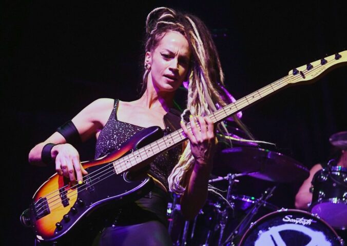 Photo shows vegan rock star Tanya O'Callaghan, who was recently interviewed by Plant Based News, playing bass onstage
