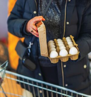 Photo shows a woman shopping in a supermarket with a trolley and holding a large, open box of eggs. According to a new survey, many US adults incorrectly believe that chicken, beef, and eggs reduce high cholesterol risk