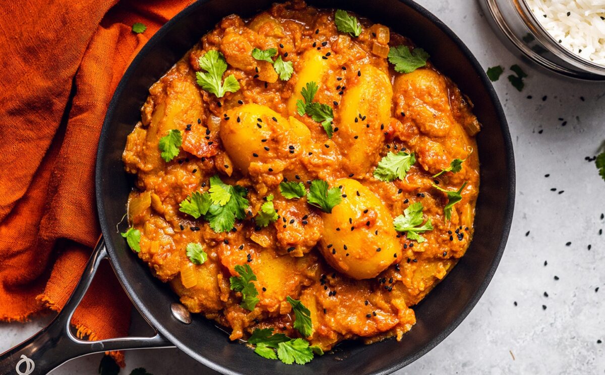 Vegan Dum Aloo with baby potatoes, tomato gravy, fresh spices, and turmeric