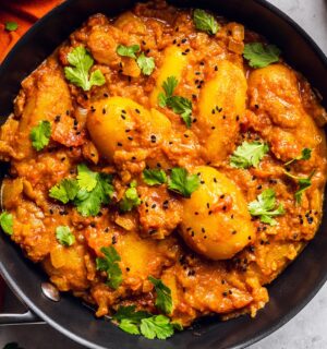 Vegan Dum Aloo with baby potatoes, tomato gravy, fresh spices, and turmeric