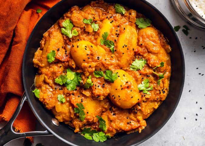 Vegan Dum Aloo with baby potatoes, tomato gravy, fresh spices, and turmeric