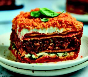 Veggie Sausage Lasagna with chickpea noodles, tomato sauce, cheese sauce, and ground veggie sausage