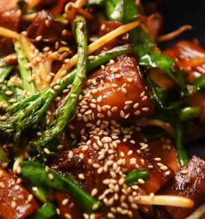 A plate of pan-fried cheung fun with smoked tofu, broccolini, garlic chives, bean sprouts and white sesame seeds, one of Wil Yeung's Chinese-style vegan recipes