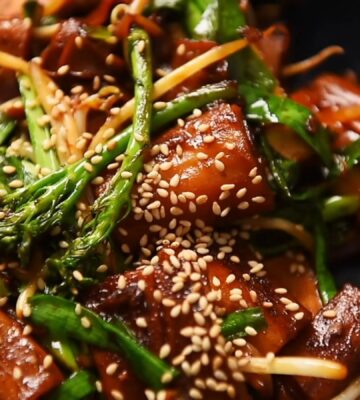 A plate of pan-fried cheung fun with smoked tofu, broccolini, garlic chives, bean sprouts and white sesame seeds, one of Wil Yeung's Chinese-style vegan recipes