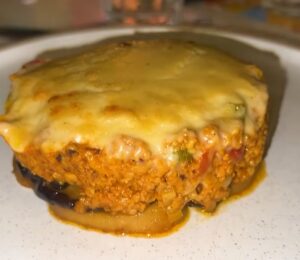 A plate of vegan moussaka topped with plant-based cheese served during a vegan food tour of Greece in Athens.
