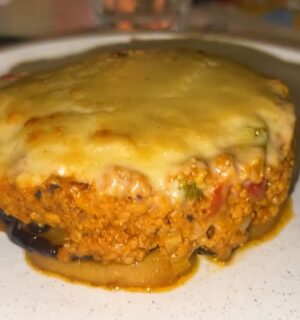 A plate of vegan moussaka topped with plant-based cheese served during a vegan food tour of Greece in Athens.