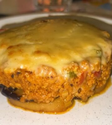 A plate of vegan moussaka topped with plant-based cheese served during a vegan food tour of Greece in Athens.