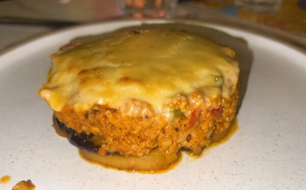 A plate of vegan moussaka topped with plant-based cheese served during a vegan food tour of Greece in Athens.