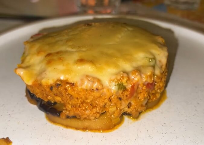 A plate of vegan moussaka topped with plant-based cheese served during a vegan food tour of Greece in Athens.