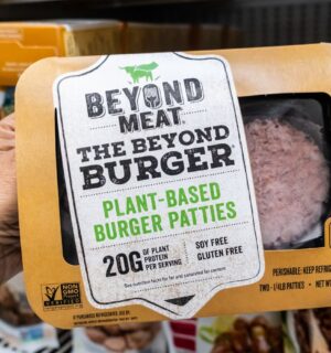 A person holds a package of Beyond Burgers in a Los Angeles supermarket aisle, to illustrate article highlighting the Beyond burger vs beef burger debate over the health impacts of plant-based vs meat products