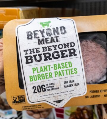 A person holds a package of Beyond Burgers in a Los Angeles supermarket aisle, to illustrate article highlighting the Beyond burger vs beef burger debate over the health impacts of plant-based vs meat products