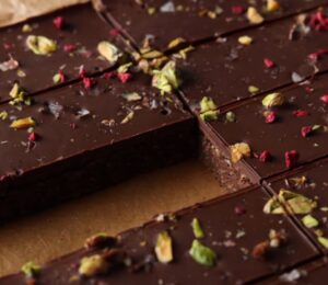 Shot of the healthy protein bars sprinkled with freeze-dried raspberries and chopped pistachios, already chilled and sliced on the baking tray
