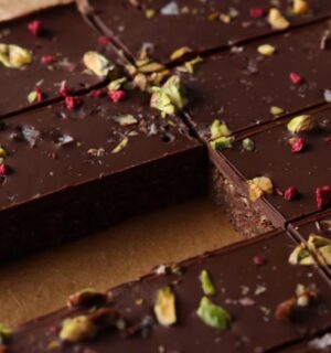 Shot of the healthy protein bars sprinkled with freeze-dried raspberries and chopped pistachios, already chilled and sliced on the baking tray