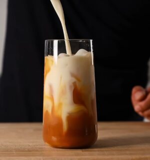 Yeung pours oat milk into the glass of vegan Thai tea