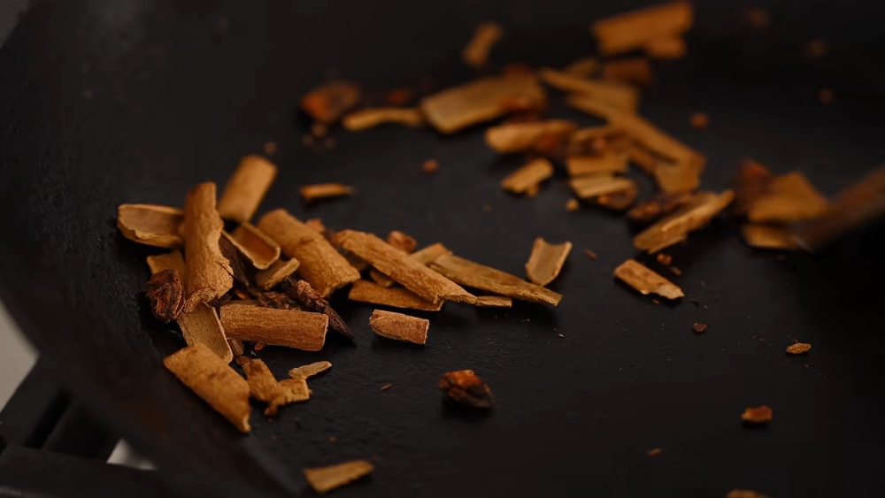Yeung toasts crushed cinnamon and star anise in a frying pan to prep his vegan Thai tea