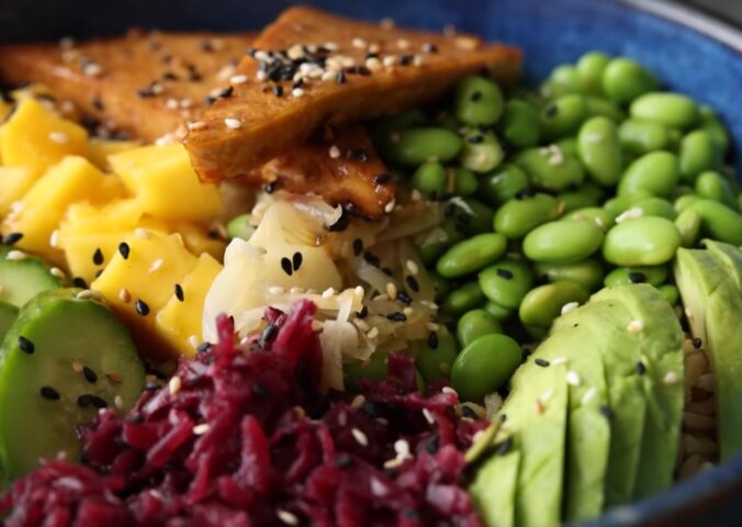 Close-up of the high-protein vegan poke bowl containing edamame, avocado, glazed tofu, and more