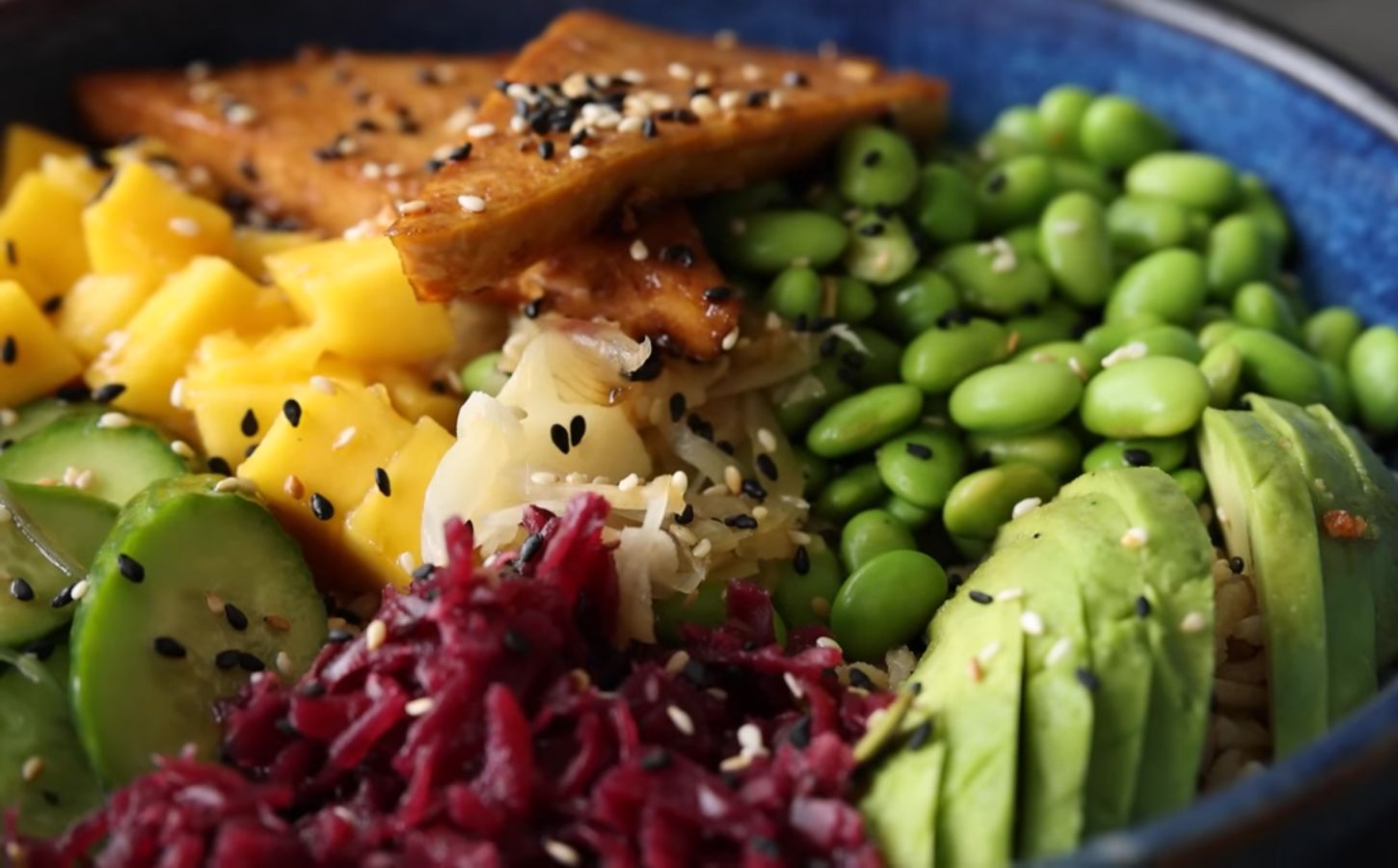 Close-up of the high-protein vegan poke bowl containing edamame, avocado, glazed tofu, and more