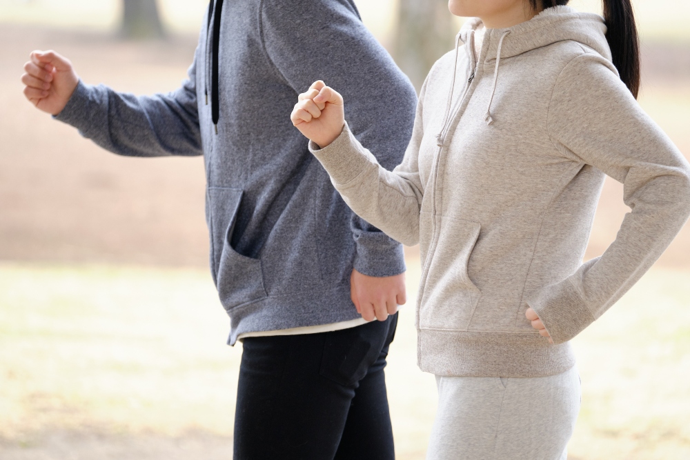 A man and woman jogging outdoors in sports clothes, showing healthy lifestyle habits that may influence research findings on nattokinase and artery plaque