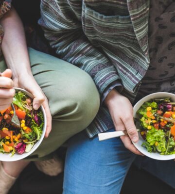Photo shows a couple eating salad out of a bowl. Could adopting a plant-based or plant-rich diet make you more attractive? A new narrative review has found that eating less meat and more plants can change how you look, smell, and feel, and benefit your overall health.