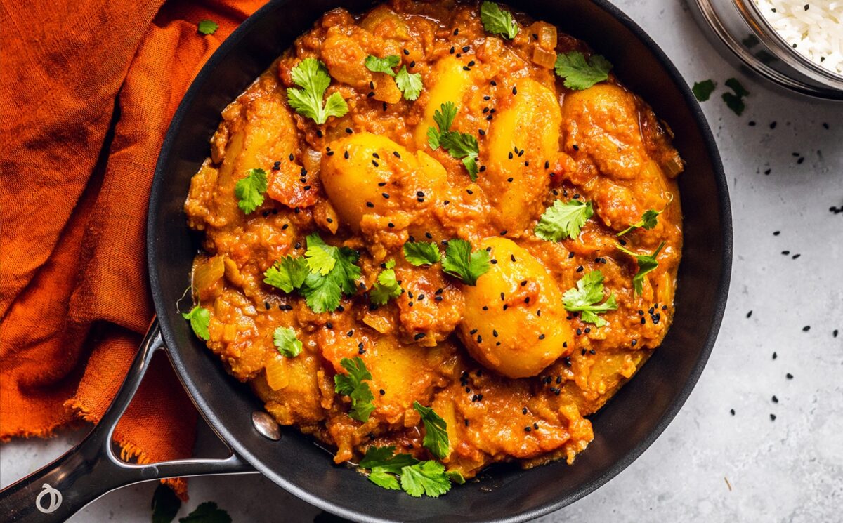Vegan Dum Aloo with baby potatoes, tomato gravy, fresh spices, and turmeric for plant-based meals that keep you full