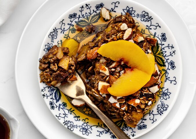 Ginger Peach Baked Oatmeal with rolled oats, frozen peaches, raisins, and almonds
