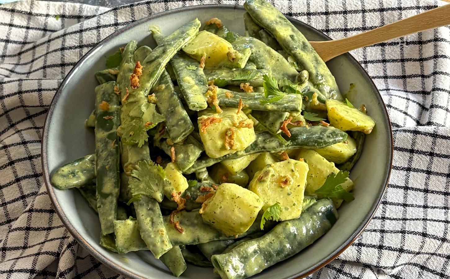 Herby Runner Bean And Potato Salad with dressing served with capers, coriander, and crispy onions