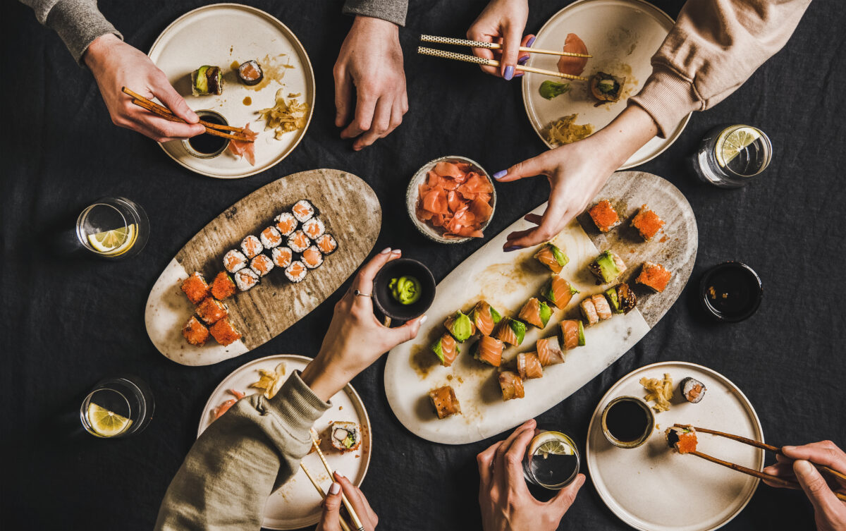 Photo shows a family's hands as they reach towards a shared, Japanese sushi dinner. The Japanese government has published a draft public-private investment roadmap worth USD $2.3 trillion and including more than $6.2 billion for novel food technologies, such as plant-based and alternative proteins