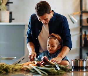 Photo shows a Dad chopping fresh vegetables with his daughter. A new study has found that children and young people around the world are not eating enough nutritious, sustainable, plant-based foods
