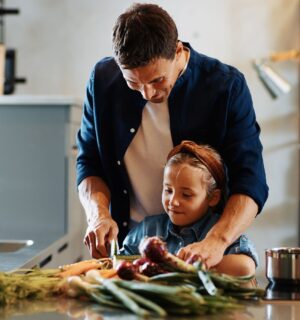 Photo shows a Dad chopping fresh vegetables with his daughter. A new study has found that children and young people around the world are not eating enough nutritious, sustainable, plant-based foods