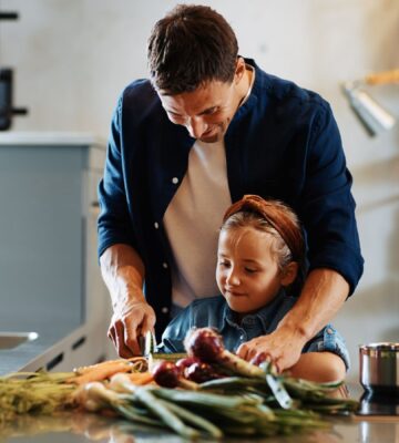 Photo shows a Dad chopping fresh vegetables with his daughter. A new study has found that children and young people around the world are not eating enough nutritious, sustainable, plant-based foods