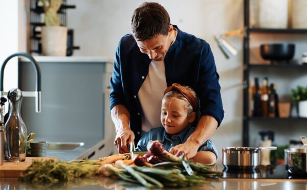 Photo shows a Dad chopping fresh vegetables with his daughter. A new study has found that children and young people around the world are not eating enough nutritious, sustainable, plant-based foods
