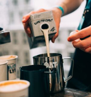 Photo shows a barista pouring Oatly Barista oat milk into a jug in a cafe. Oatly has reported profitable growth in the second quarter of 2026, primarily driven by sales of its Barista milk line