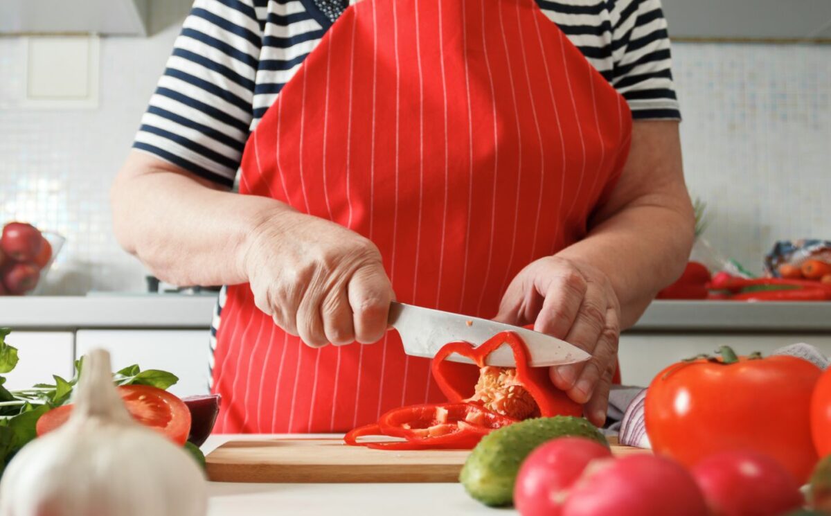 Photo shows an older woman preparing fresh vegetables in her kitchen at home. A new study has found that following the plant-rich Planetary Health Diet can cut heart disease risk by up to 28 percent