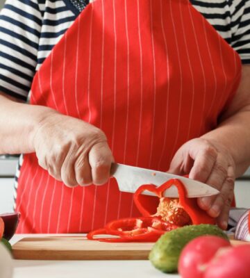 Photo shows an older woman preparing fresh vegetables in her kitchen at home. A new study has found that following the plant-rich Planetary Health Diet can cut heart disease risk by up to 28 percent