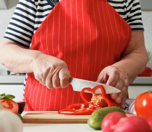 Photo shows an older woman preparing fresh vegetables in her kitchen at home. A new study has found that following the plant-rich Planetary Health Diet can cut heart disease risk by up to 28 percent