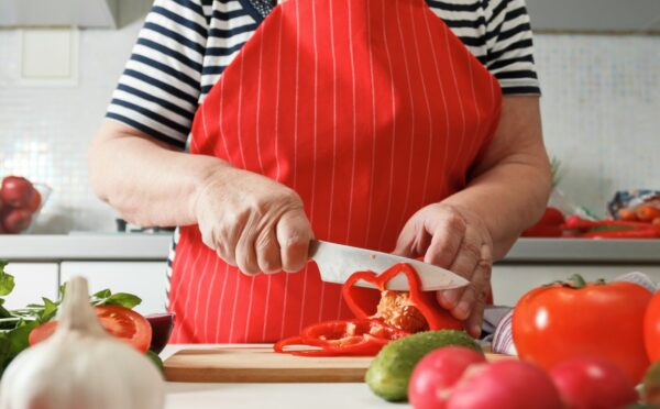 Photo shows an older woman preparing fresh vegetables in her kitchen at home. A new study has found that following the plant-rich Planetary Health Diet can cut heart disease risk by up to 28 percent