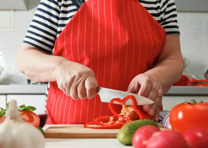 Photo shows an older woman preparing fresh vegetables in her kitchen at home. A new study has found that following the plant-rich Planetary Health Diet can cut heart disease risk by up to 28 percent