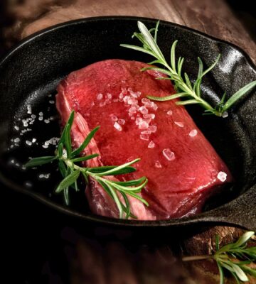 Photo shows a rare steak in a cast iron pan with rosemary and salt. Cultivated protein startup MyriaMeat has made a venison breakthrough with roe deer stem cells