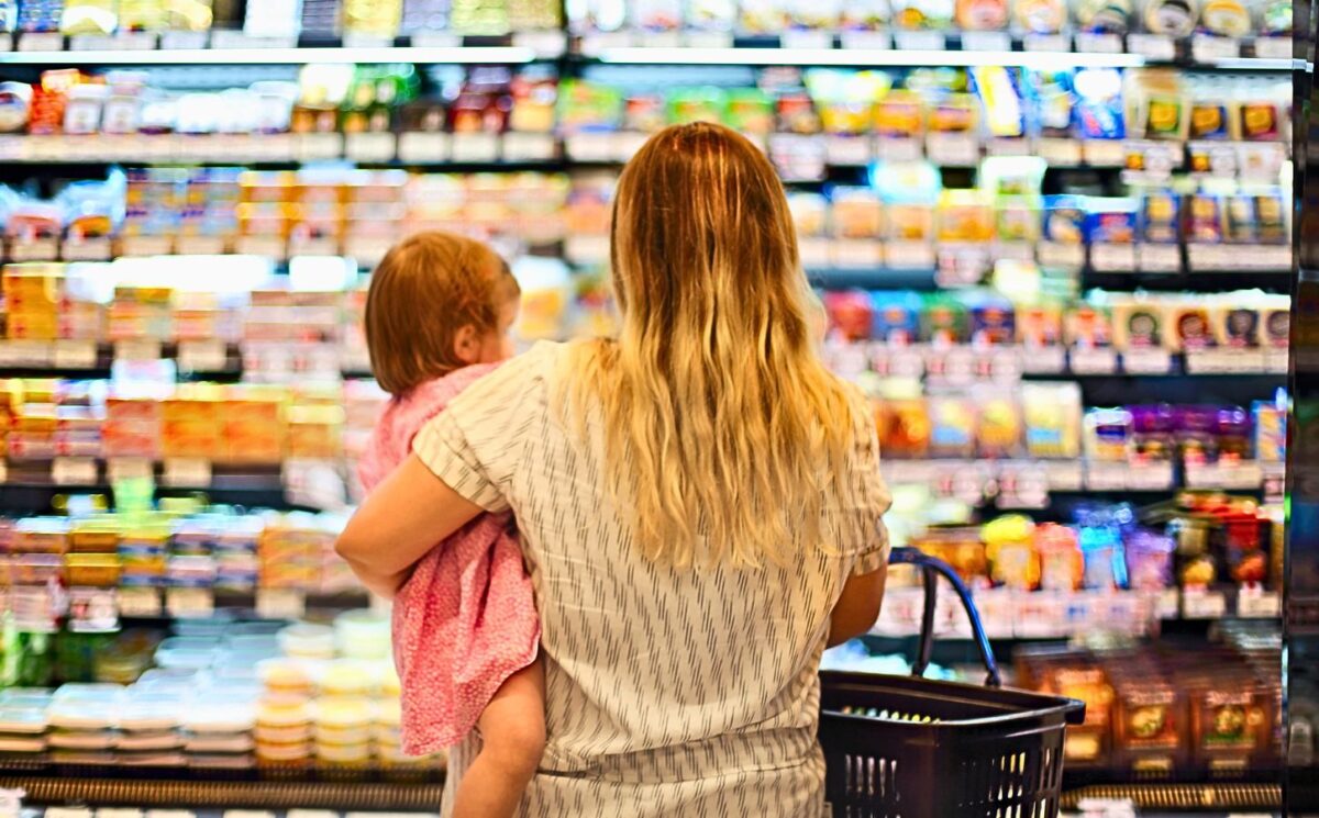 Photo shows a mother holding a baby and grocery store shopping. Over 80 percent of food for toddlers sold at US grocery stores in Austin, Texas is ultra-processed, according to a new audit